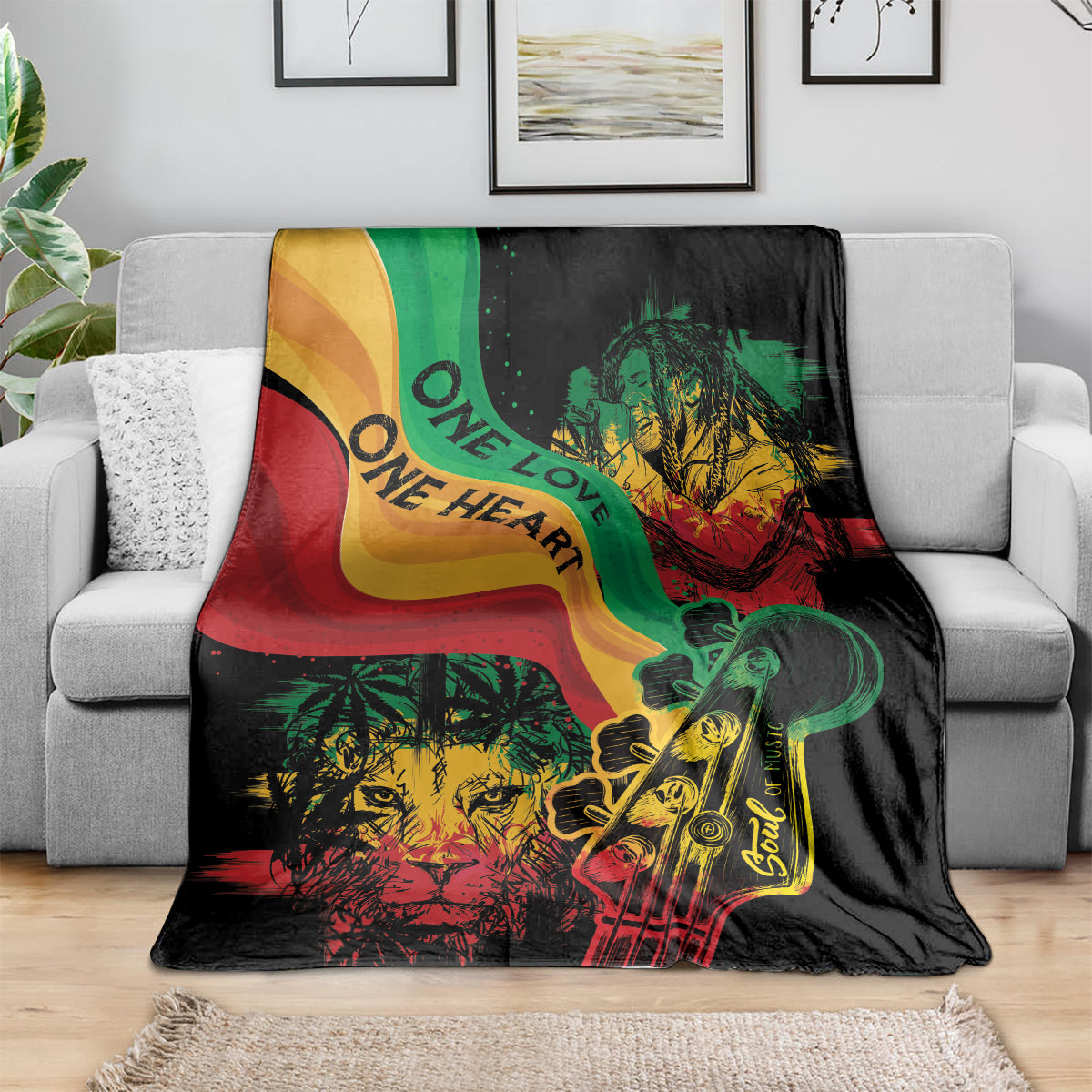 Reggae-themed throw blanket on gray sofa, black with green red yellow lion and guitar artwork.