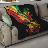 Black quilt blanket on a sofa with colorful reggae heart, lion and guitar design centerpiece.