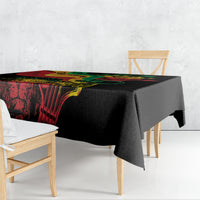 Black tablecloth with red, green, and yellow graphic design hanging over the table edge