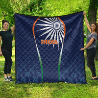 Blue India quilt blanket with sunburst logo and INDIA text, spread on grass