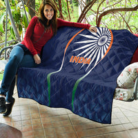 Blue India quilt blanket with sunburst logo and INDIA text, laid over sofa