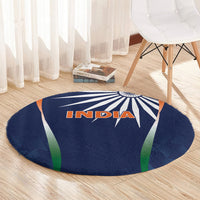 Round blue rug showing INDIA lettering with starburst rays and green/orange trim
