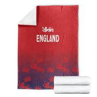 Red England blanket folded with draped edge; crowns and lions pattern, with England logo