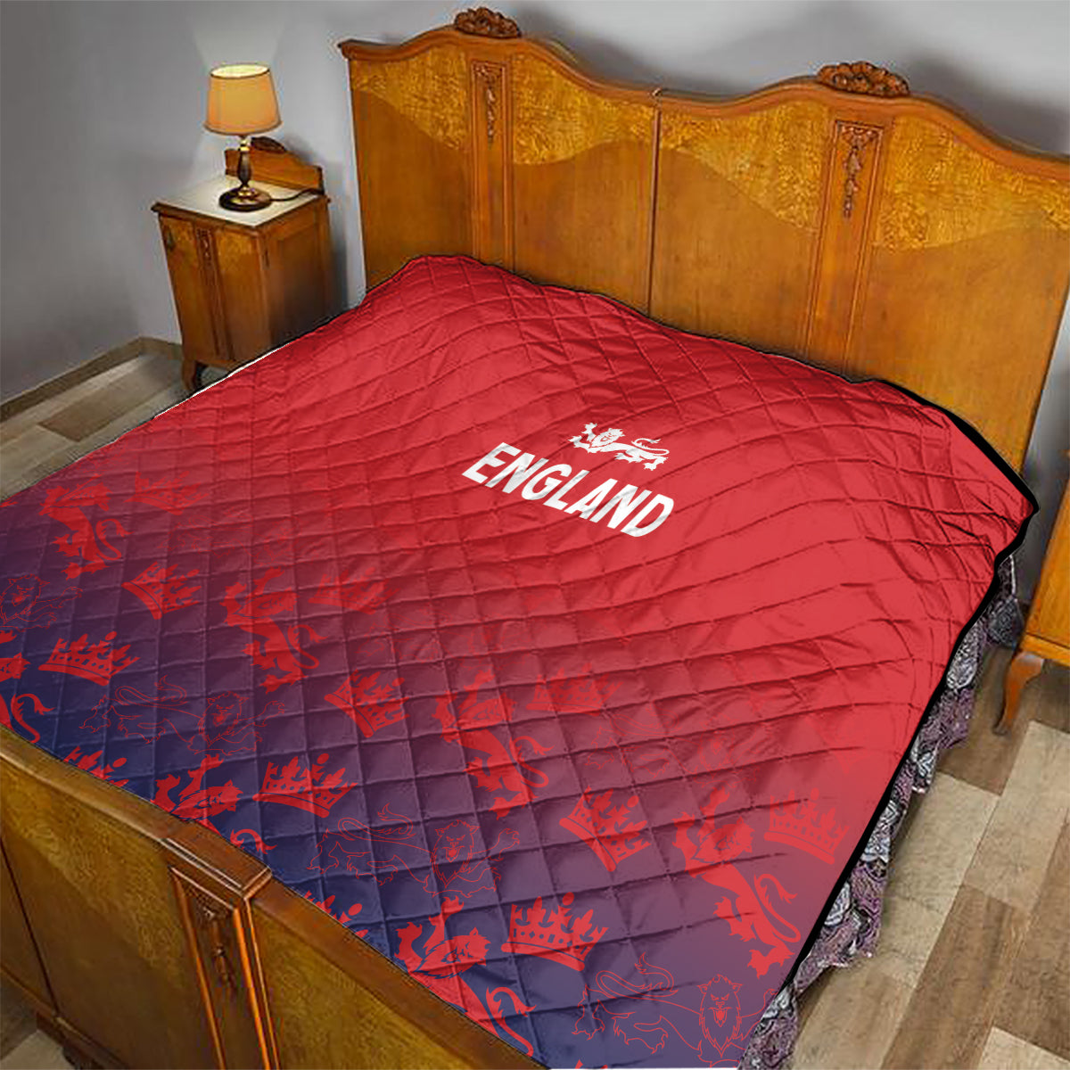 Red England quilt draped on wooden bed frame, diamond stitching and crest logo.
