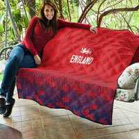Red England quilt blanket spread on patio seat, quilted texture with crest logo and text.