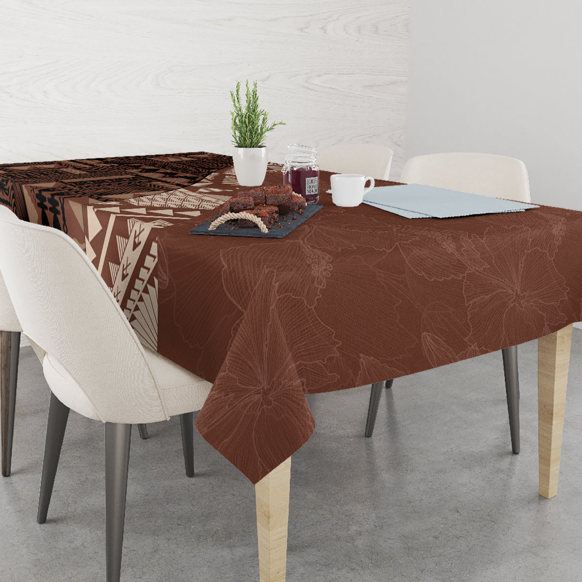 Brown tablecloth on dining table with tapa symbols, geometric stripes, and leaf branch motif