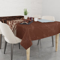 Brown tablecloth on dining table with tapa symbols, geometric stripes, and leaf branch motif