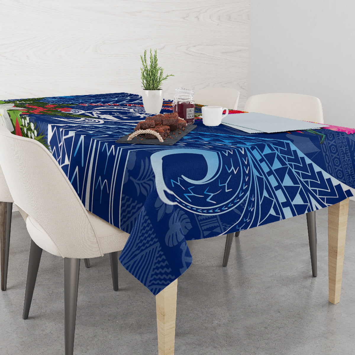 Blue Christmas tablecloth with turtle emblem and geometric tapa motifs on table