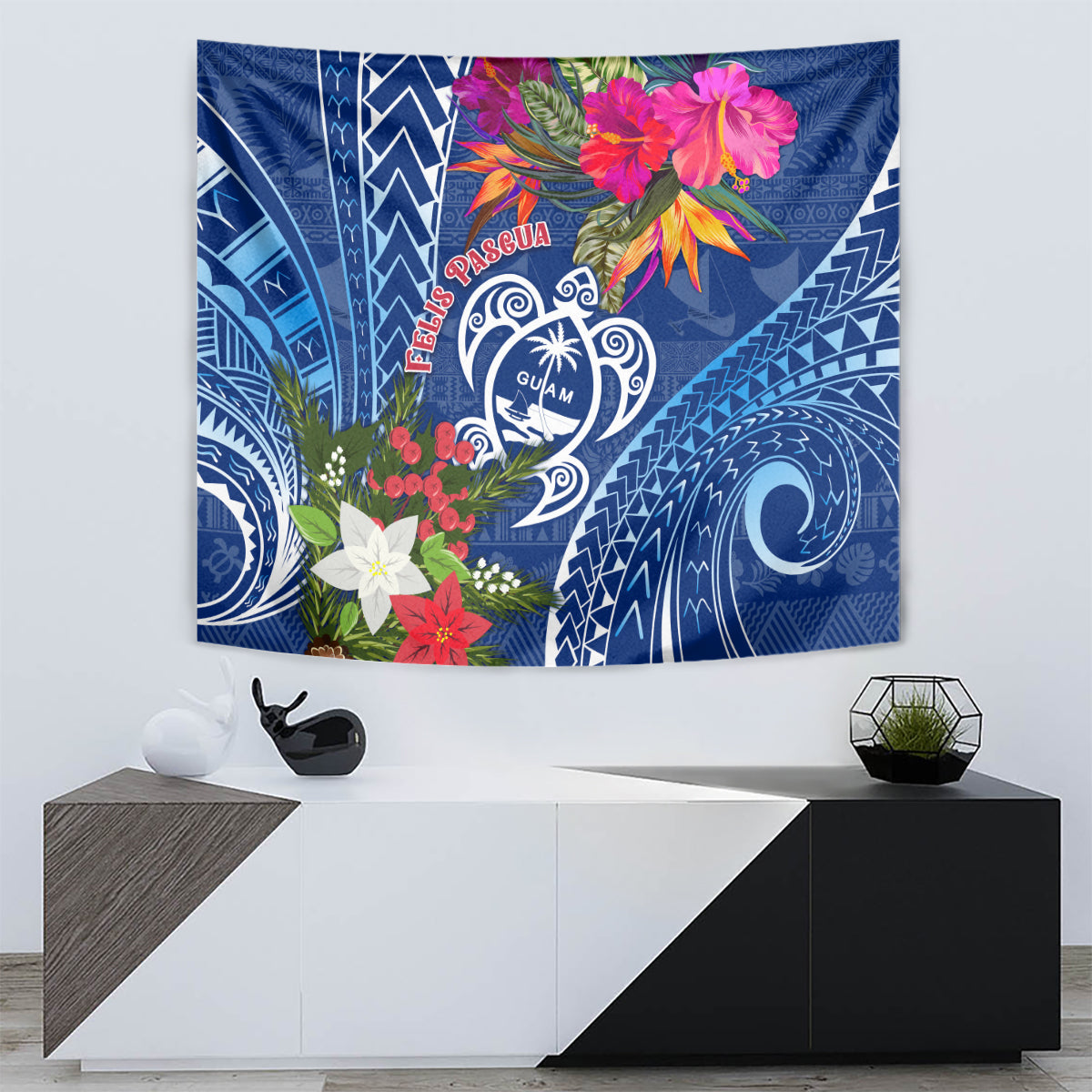 Blue rectangular tapestry with Guam turtle emblem, Pasqua lettering, and colorful flower crest.