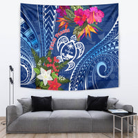 Blue tapestry with Guam turtle emblem, red Pasqua text, and pink floral accents.