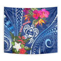 Blue tapestry close-up with Guam turtle heart logo, flowers, and patterned swirls.