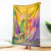 Colorful Mardi Gras blanket draped on display, with 'It's Mardi Gras Time' text and mask