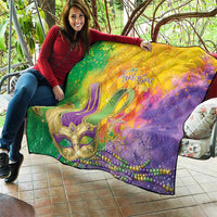 Multicolor quilt held on patio with Mardi Gras text, fleur-de-lis, and star decoration
