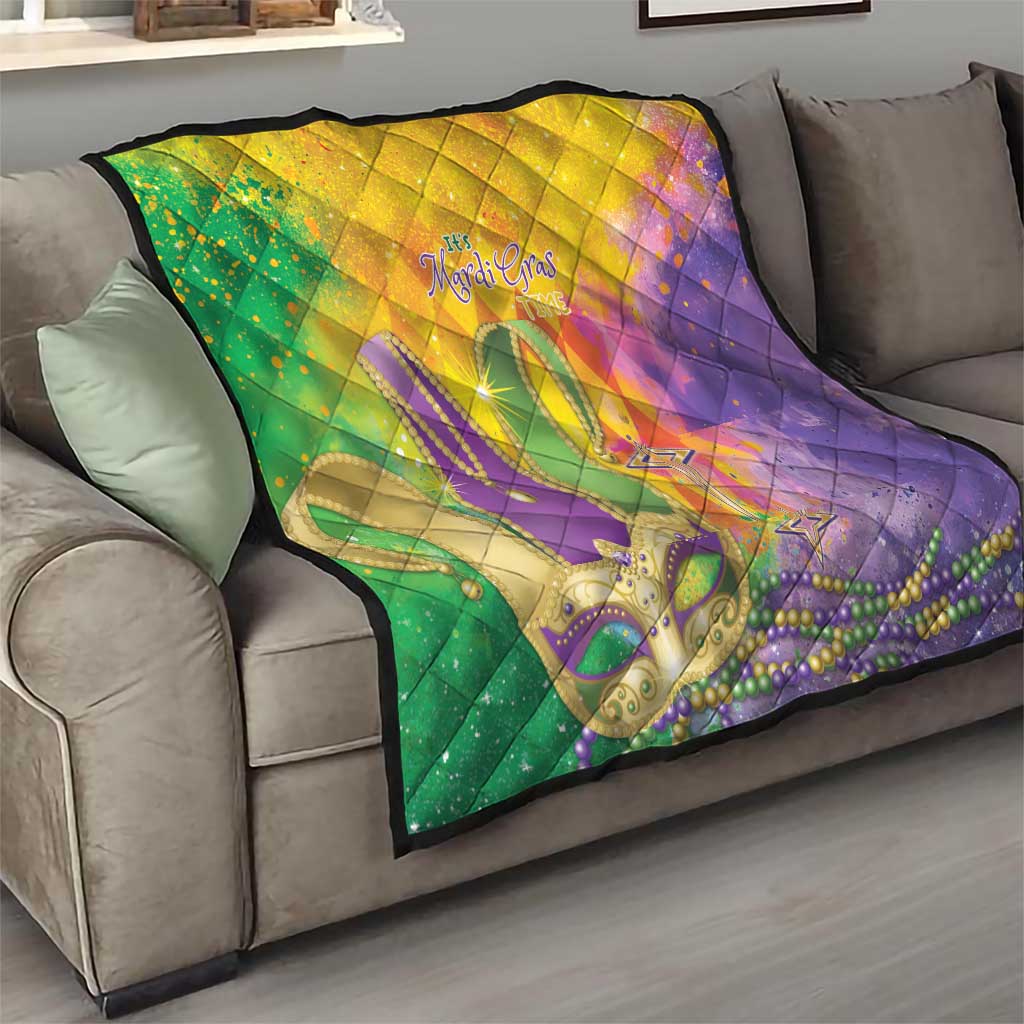 Multicolor quilt on sofa featuring fleur-de-lis, beads, and stars over quilted diamonds
