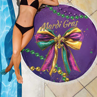 Purple round Mardi Gras beach blanket with tassel fringe, glitter bow and bead motifs close-up.
