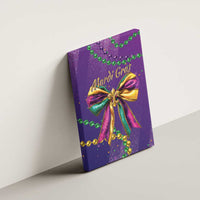 Purple canvas wall art with Mardi Gras glitter bow and green-gold bead garlands