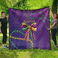Purple quilted blanket with large Mardi Gras bow and green beads over gold chain