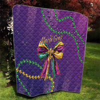 Purple quilted throw with Mardi Gras bow center design and green bead garland details