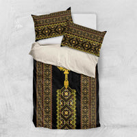 Black bedding set with gold-and-green patterned duvet and pillowcases featuring geometric borders