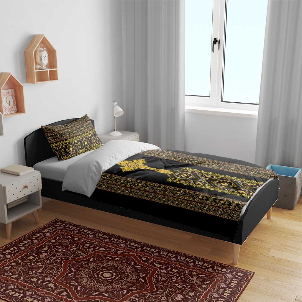 Black duvet and pillow shams with gold-and-green Ethiopian geometric pattern on bed