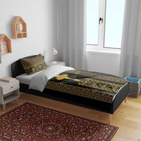 Black duvet and pillow shams with gold-and-green Ethiopian geometric pattern on bed