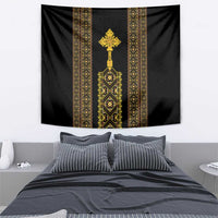 Black wall tapestry featuring gold vertical bands and central cross-like symbol.