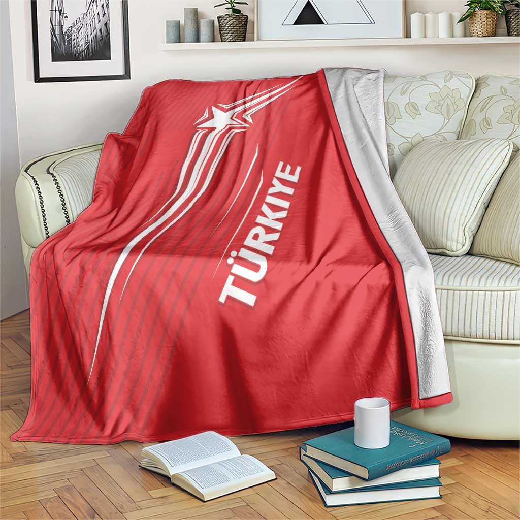 Red Turkey football blanket draped on a couch, showing crescent-star and Turkish text