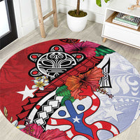 Red round rug with black tribal design, blue-and-white figures, and floral accents.