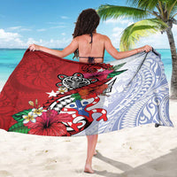 Tribal print sarong draped around the body, red and light-blue with floral and turtle art