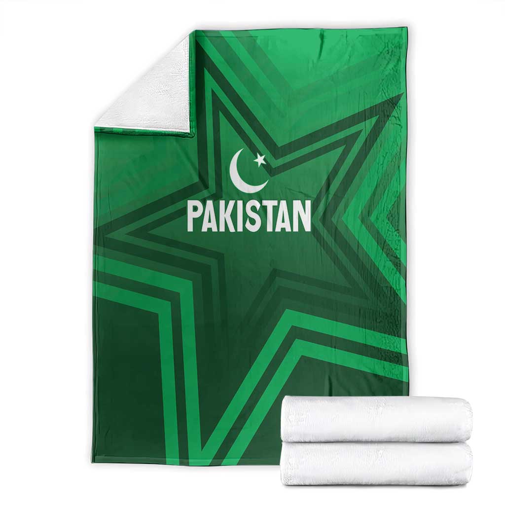 Green Pakistan sports blanket folded with stacked white towels, star-and-crescent logo