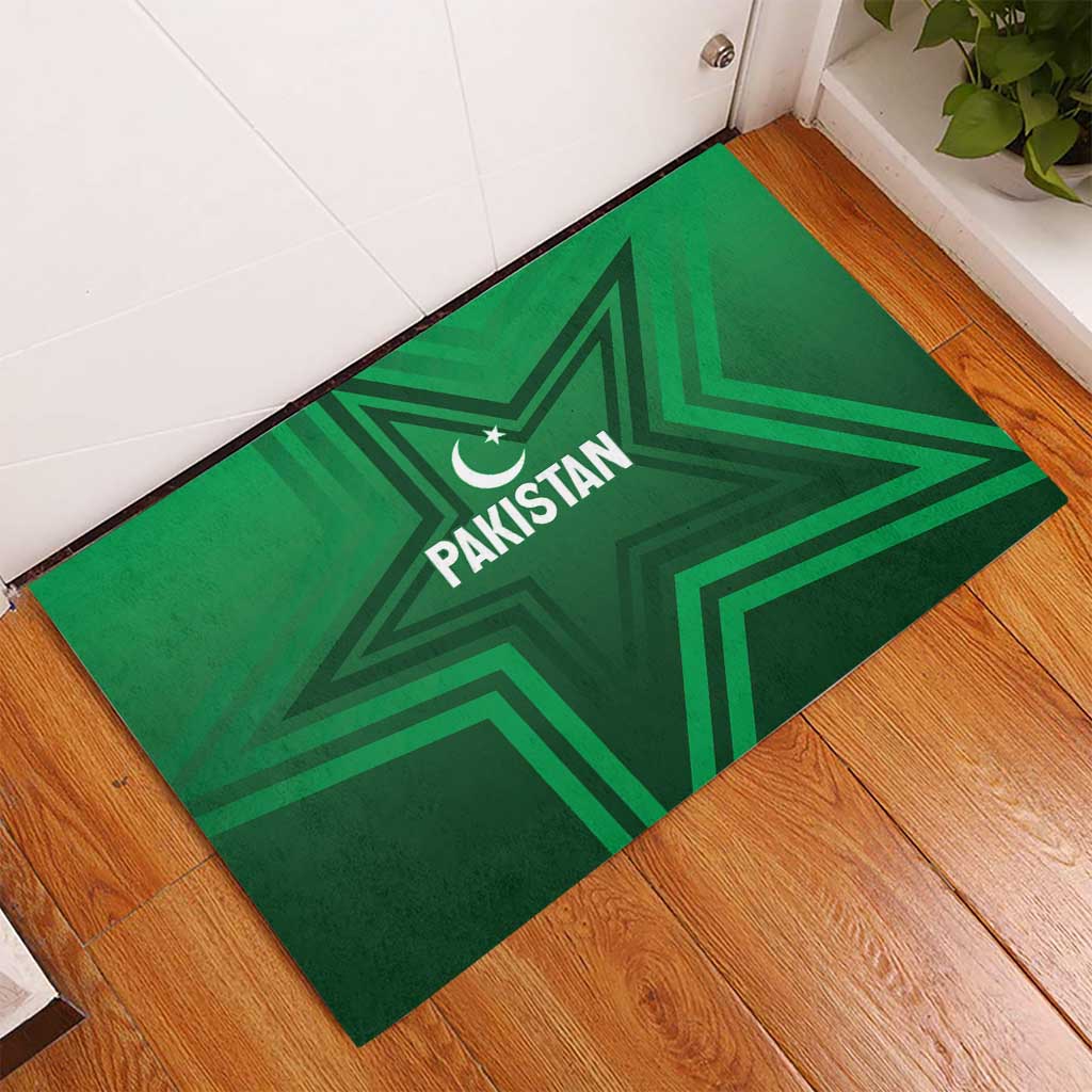 Green rubber doormat on wooden floor featuring Pakistan star and crescent