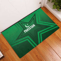 Green rubber doormat on wooden floor featuring Pakistan star and crescent