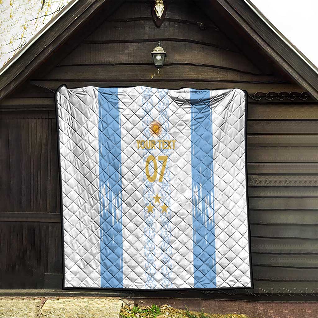 White and light-blue quilt hung outdoors, featuring crest, stars, and “YOUR TEXT 07”.