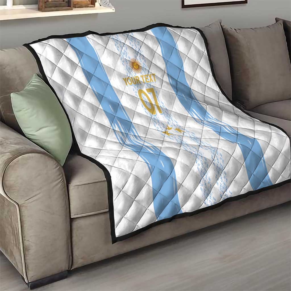 Quilt draped over a sofa: white base with light-blue curved diagonal stripes and “07”.