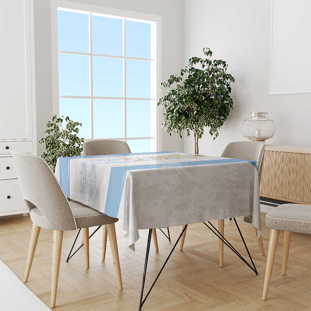 Custom blue-and-white tablecloth on dining table with chairs, emblem stripe and side border