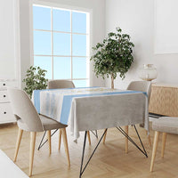 Custom blue-and-white tablecloth on dining table with chairs, emblem stripe and side border