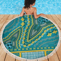 Teal round beach blanket with dashiki print and white fringe on wooden deck near pool