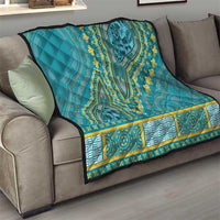 Teal dashiki-style quilt on gray sofa with yellow geometric-and-floral border