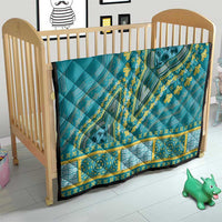 Teal dashiki-style quilt on wooden crib with yellow geometric border and medallion