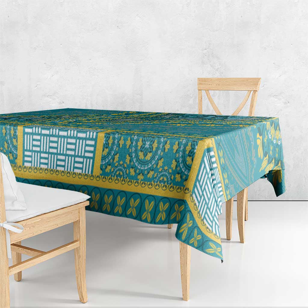 Teal dashiki tablecloth with bold yellow border, repeating symbols, and patterned panels
