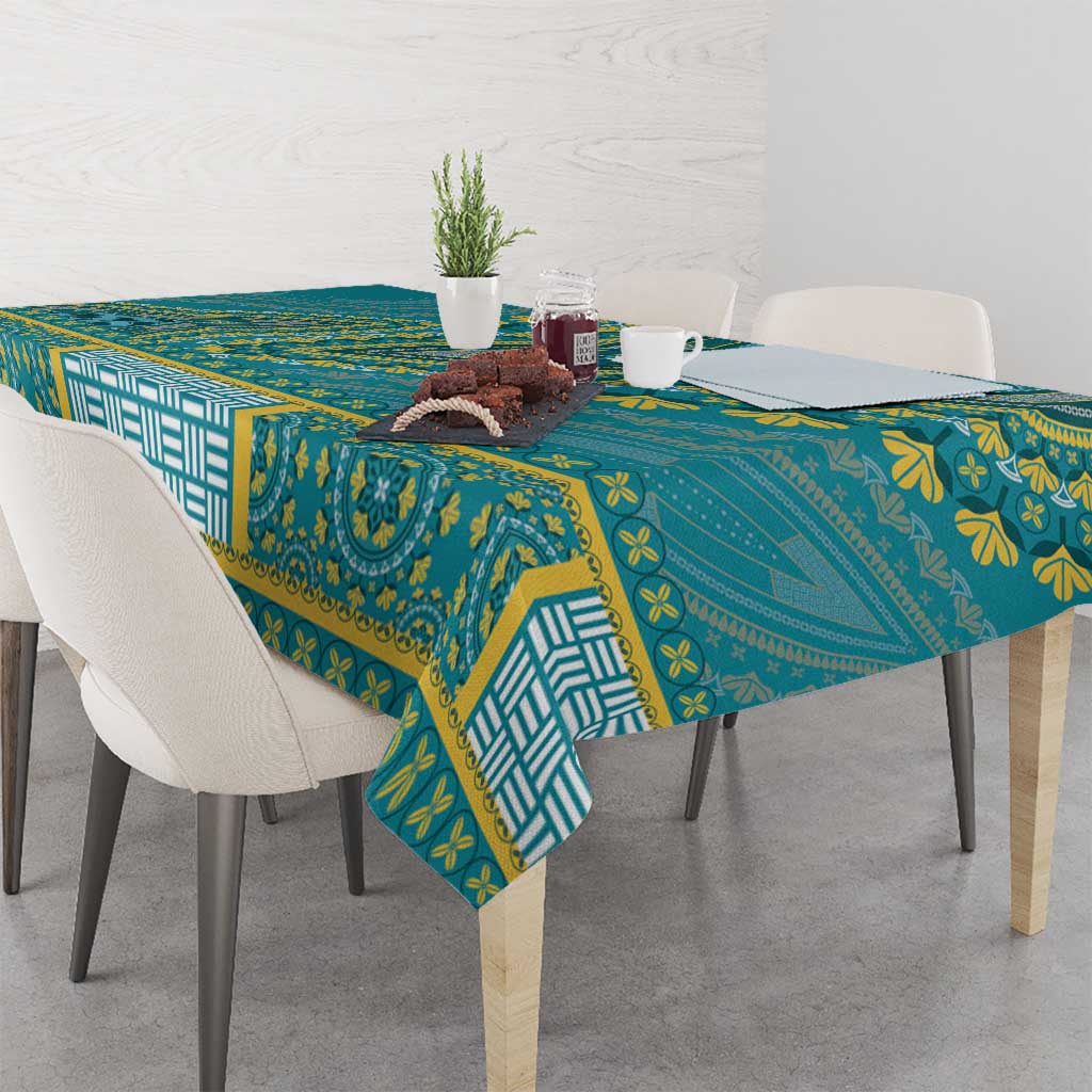 Teal dashiki tablecloth with patterned border and draped corner over table
