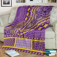 Purple dashiki blanket on couch, featuring wide patterned border and central square panel