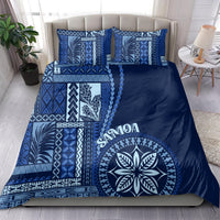 Blue bedding set with navy cover, large leaf emblem, and matching patterned pillowcases