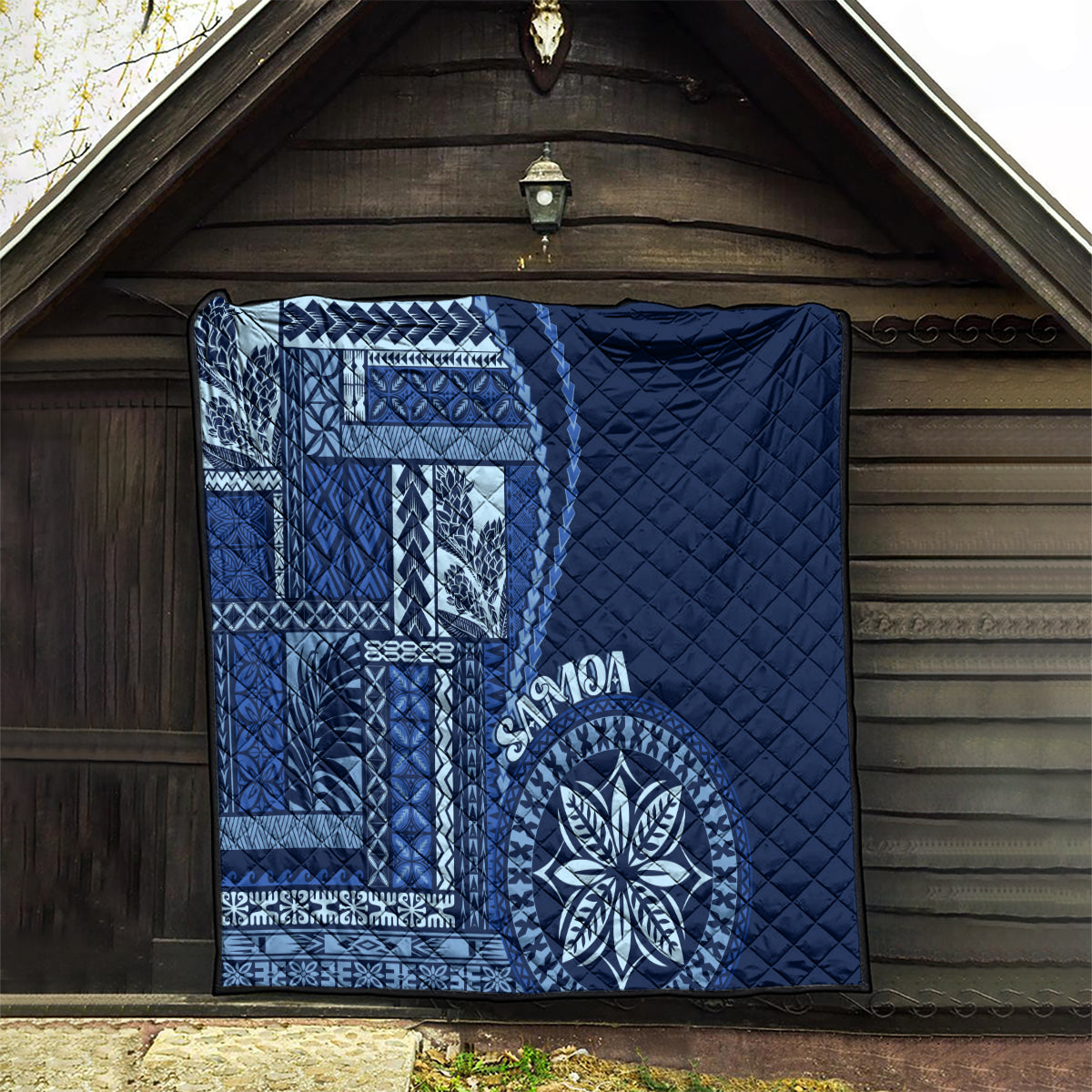 Navy blue quilt with Samoa siapo geometric panel and round floral medallion, quilted fill