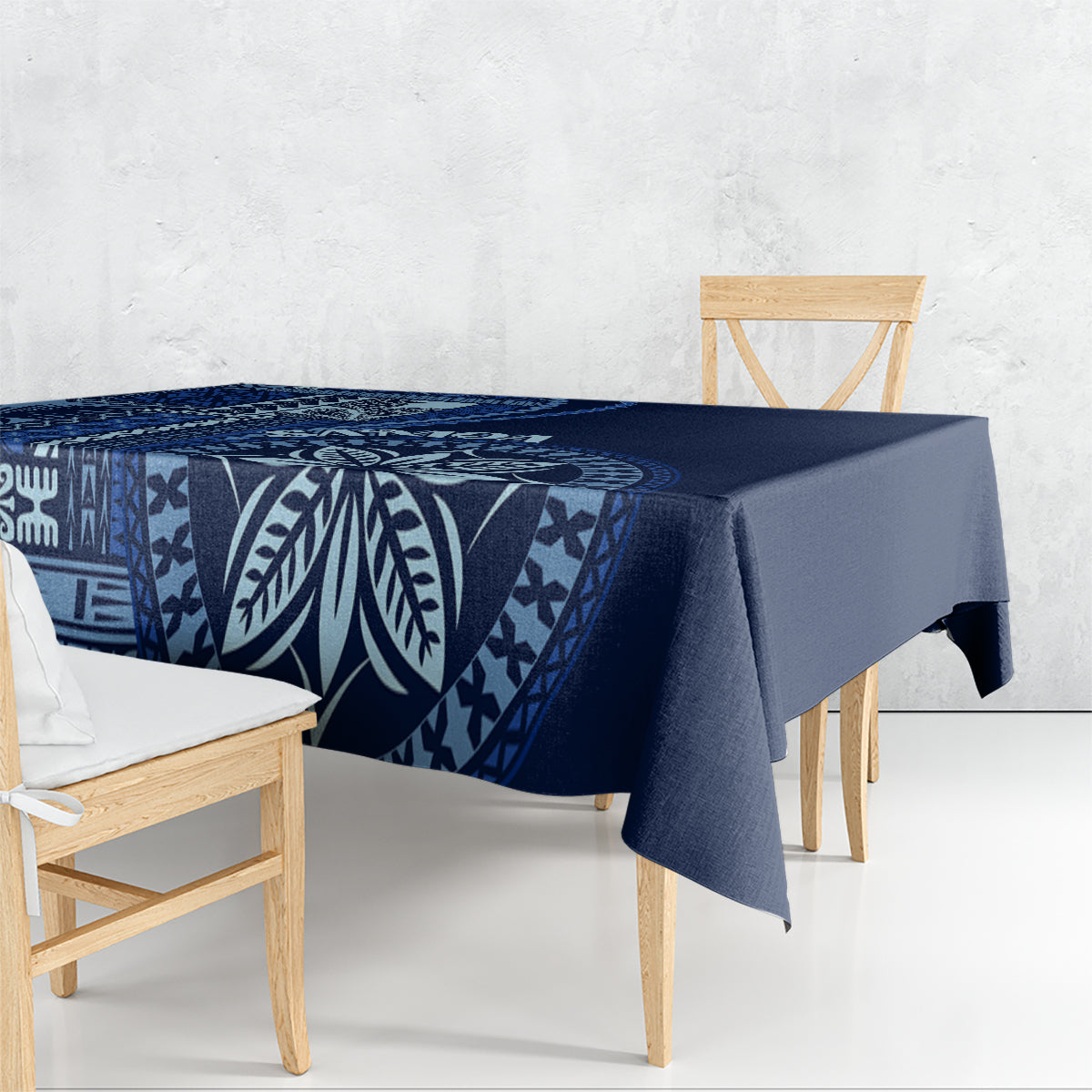 Blue patterned tablecloth draped on dining table, featuring leaf and geometric motifs