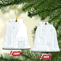 White ceramic bell-shaped ornament with blue patterned siapo design, hanging on gold cord.
