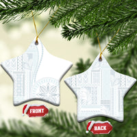 White ceramic star-shaped ornament with blue patterned siapo design hanging on gold cord.