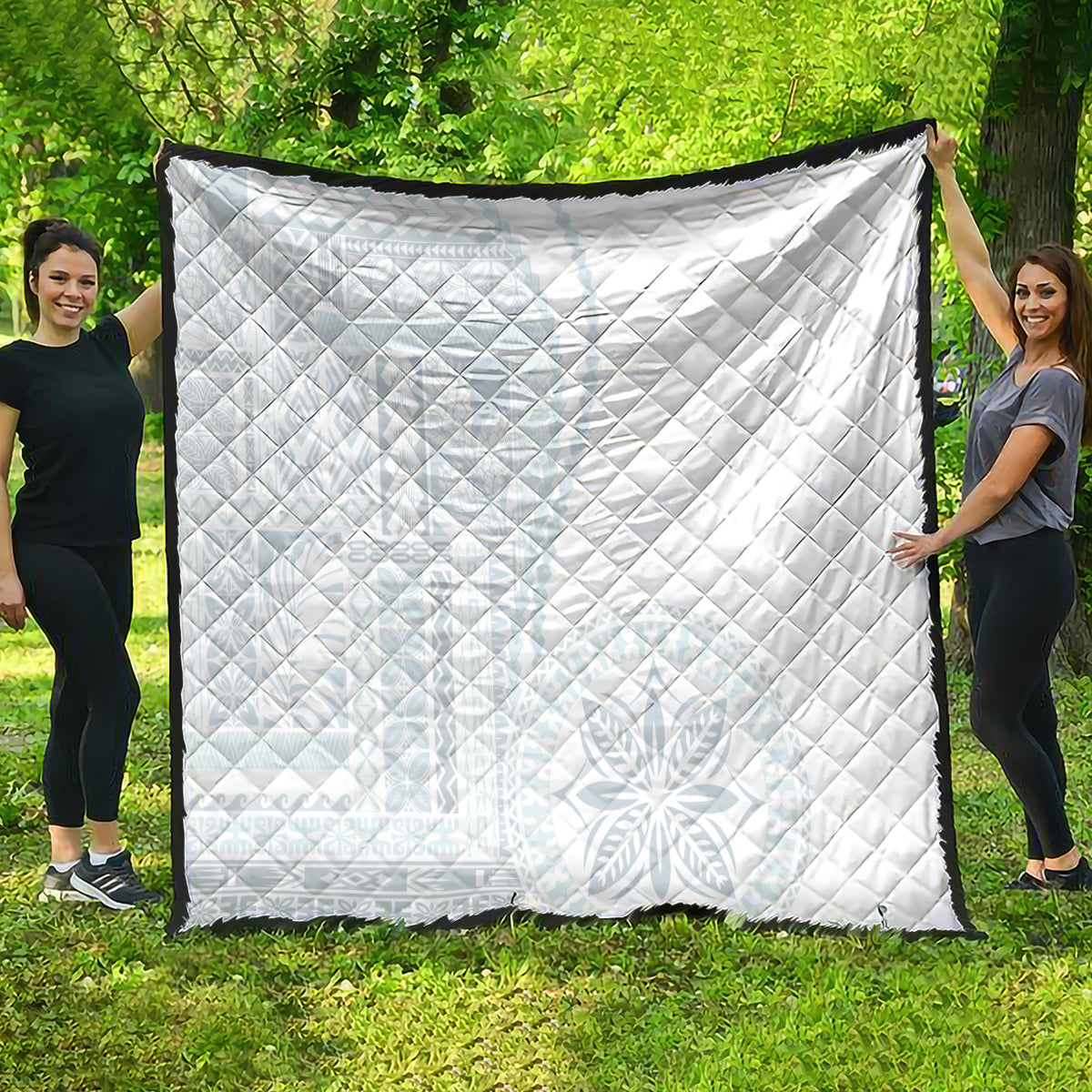 White quilt featuring quilted diamond design with dark edge trim