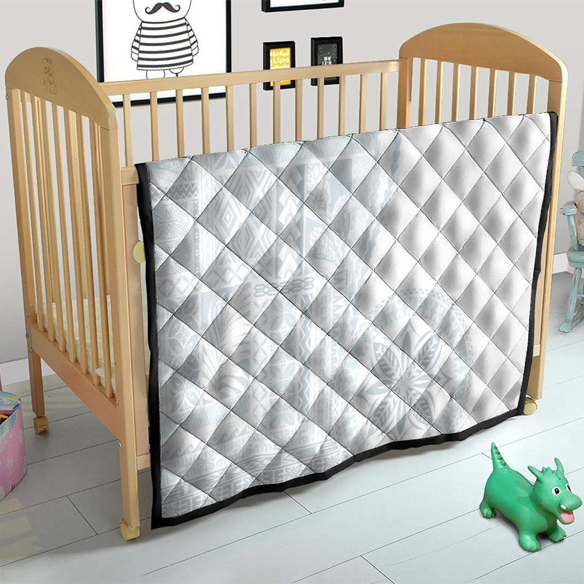 White diamond-quilted baby blanket with dark edge trim on wooden crib
