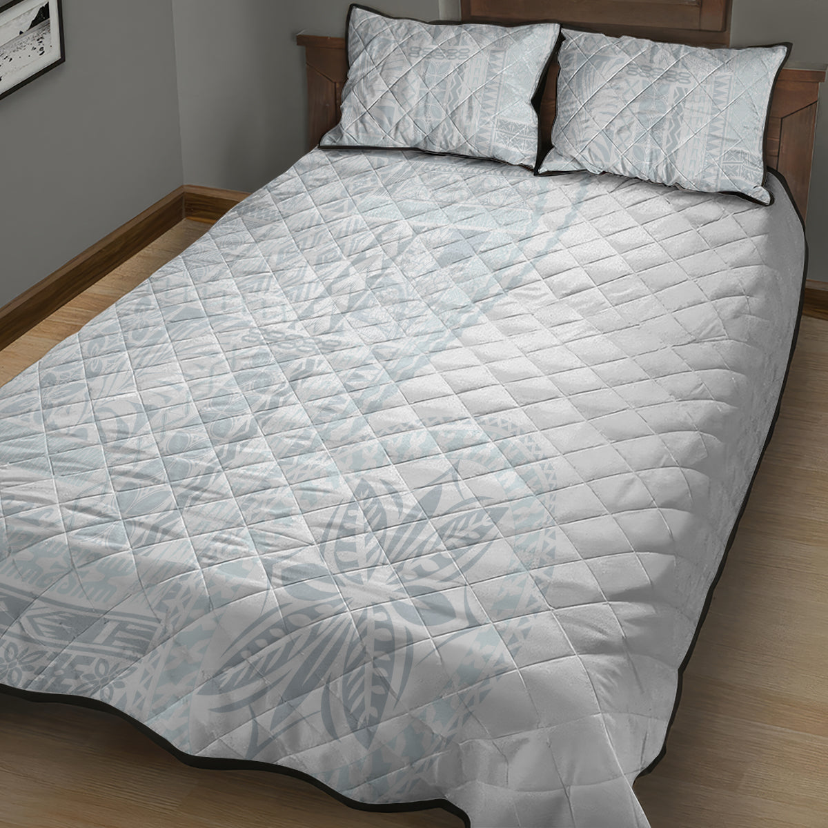 White quilt and two pillow shams with black-edged border and light geometric pattern